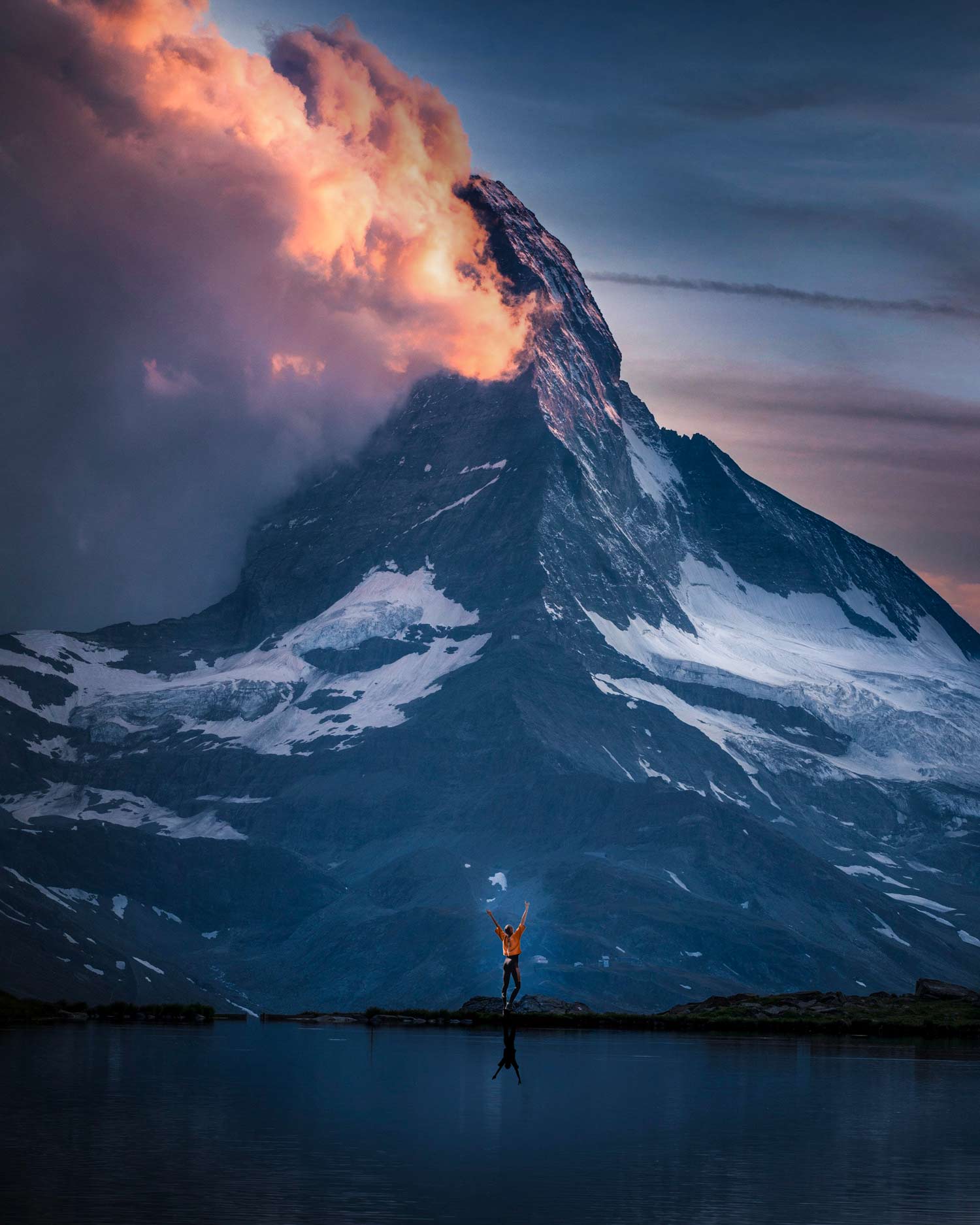 Lady at base of mountain looking up. Late in the day with cloud cover.